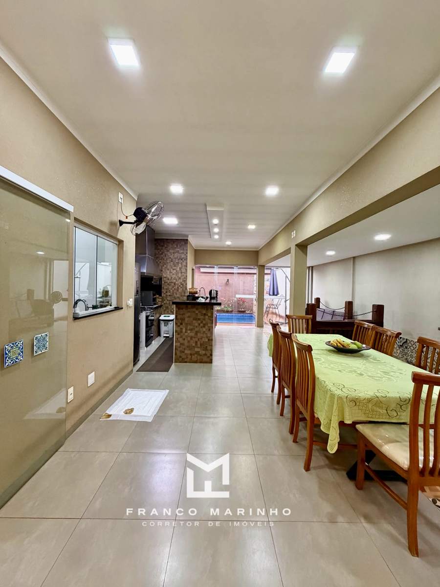 Sala de jantar integrada ao estar com lustre de cristal