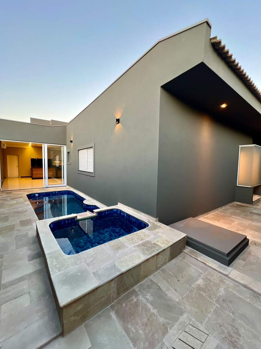 Piscina aquecida com hidromassagem e deck em pedra