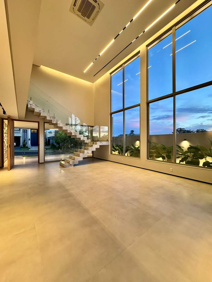 Escada flutuante em mármore com guarda-corpo de vidro