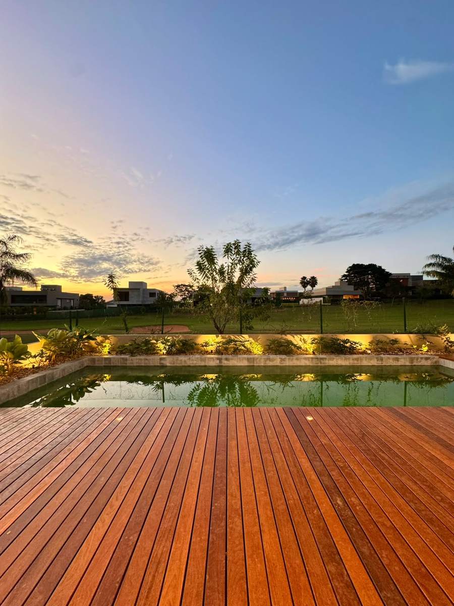 Deck e piscina de frente para o campo de golfe ao pôr do sol