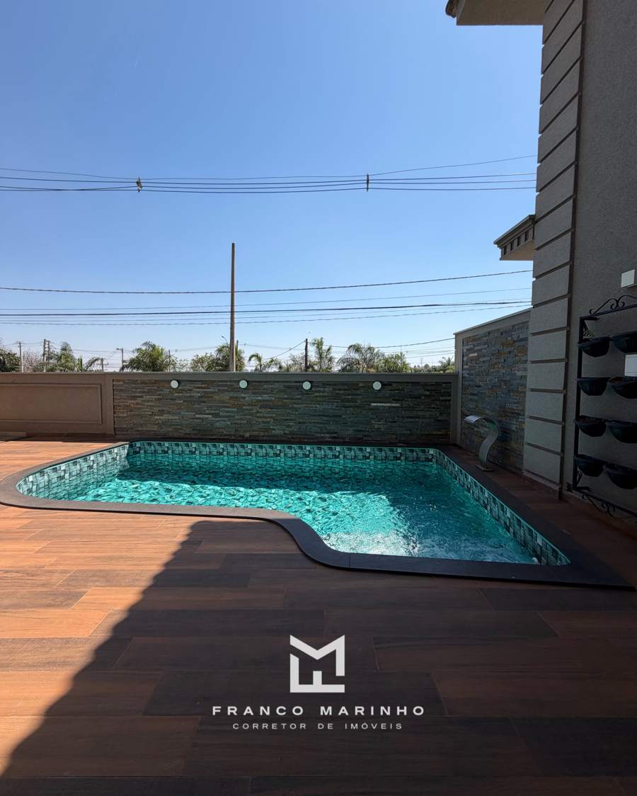 Piscina com cascata e deck amadeirado