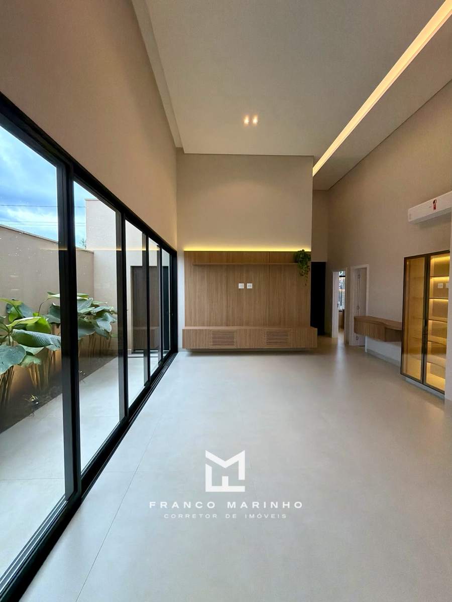 Sala com painel em madeira e janelas do chão ao teto